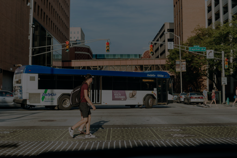 man walks in front of downtown bus