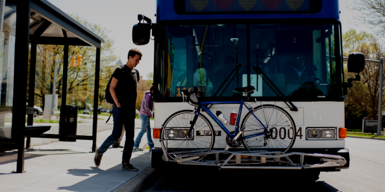 Bus picks up two people at bus stop